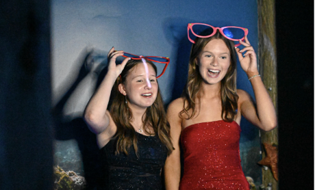 Amelia Fromeyer (11) and Liz Perkins (11) having fun with prop in the photo booth. 

